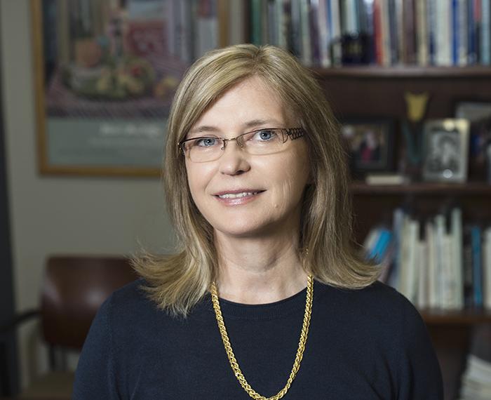Cynthia Golden smiling in front of bookshelf