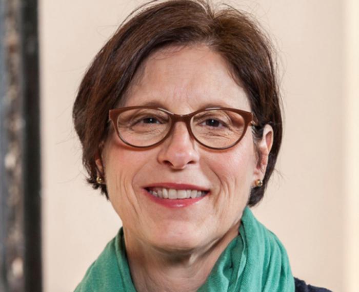 Mary Beth Rauktis smiling in glasses and green scarf