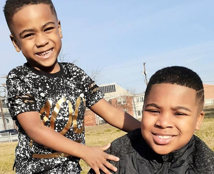 Two boys in black t-shirts playing in a field