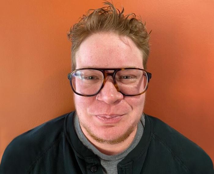 a person in front of an orange background