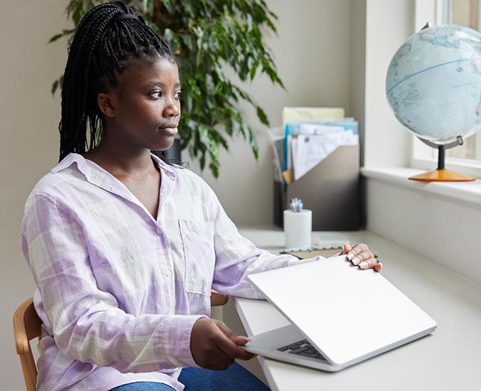 a young Black woman closing a laptop