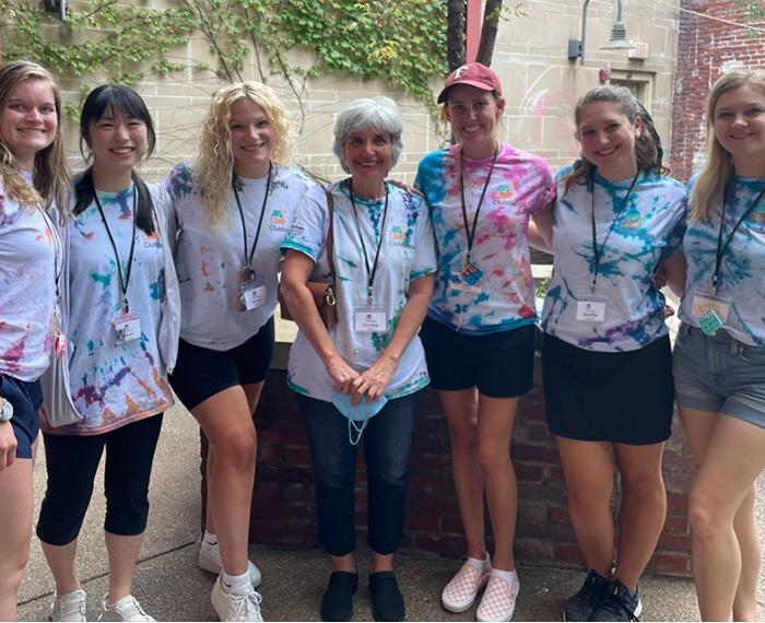 seven people in tie-dye shirts