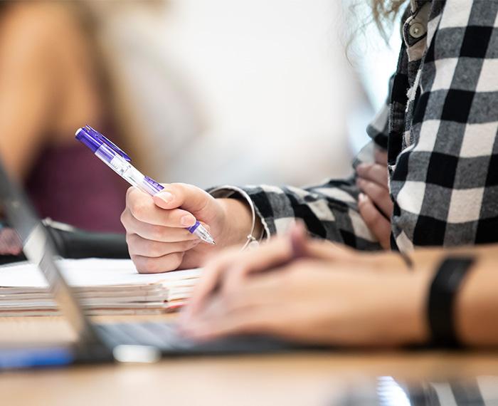 a student holding a pen