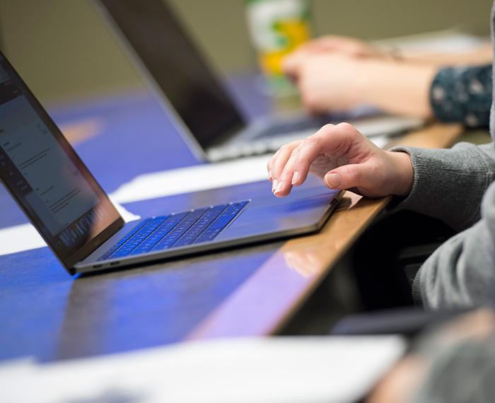 A hand on a laptop trackpad.