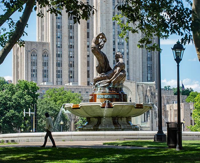 A person walks by a fountain