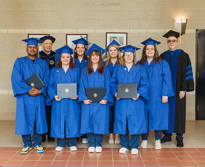seven graduates in royal blue robes