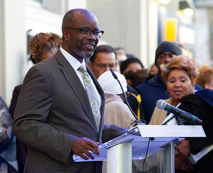 John Wallace addresses a crowd at a podium
