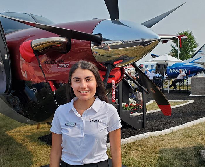 Linares stands in front of a red plane with a propellor