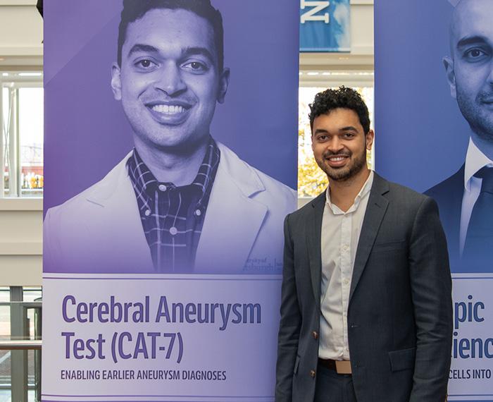 Mittal stands next to a poster with his photo and project name