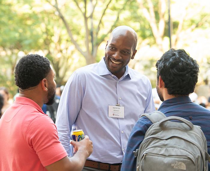 Bonner talks with two people at a picnic