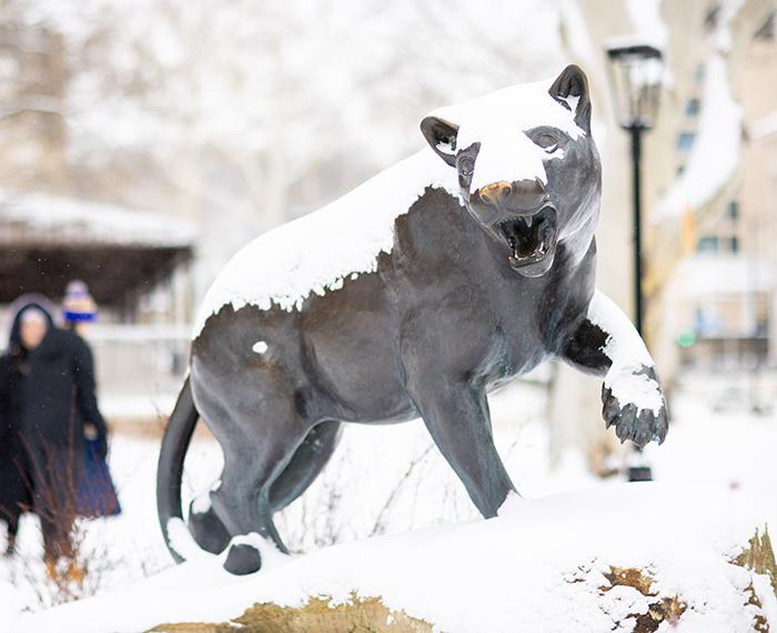 A snow-covered panther statue