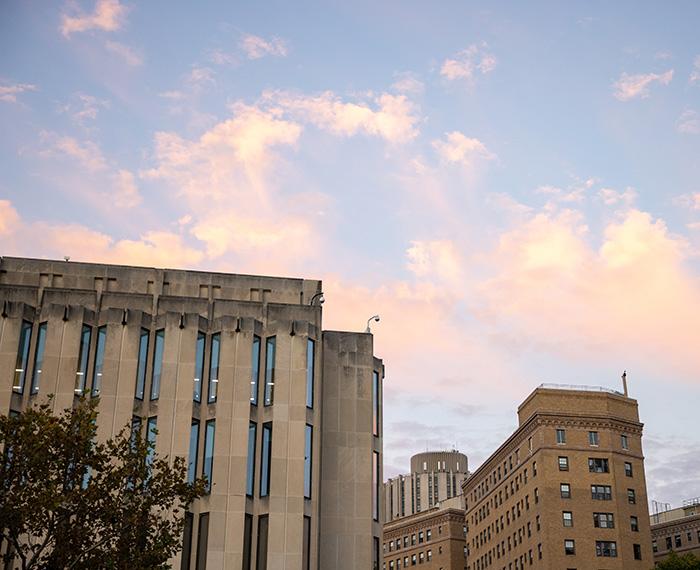 The top of Hillman Library against a blue sky and pink clouds