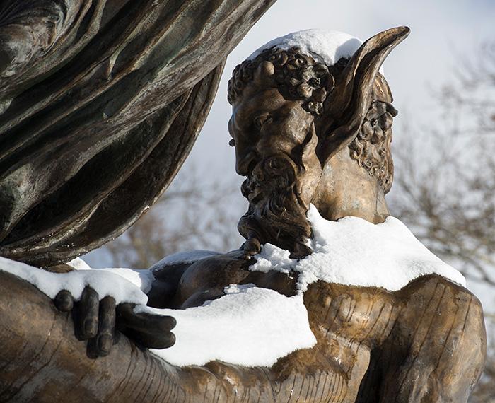 A snow-covered statue of a bearded man