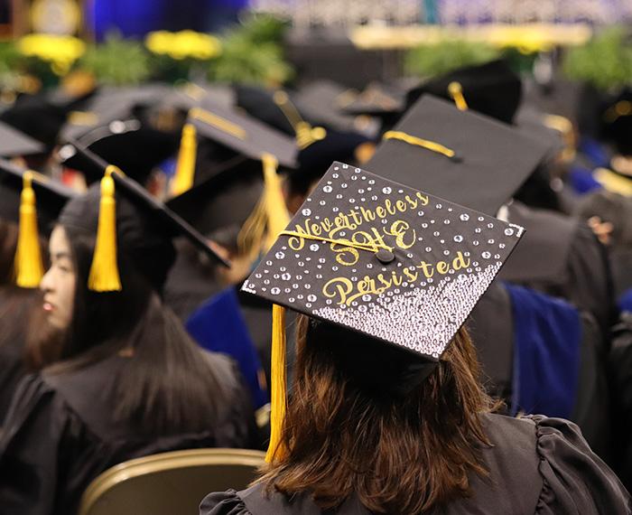A graduation cap, decorated with rhinestones, reads Nevertheless She Persisted