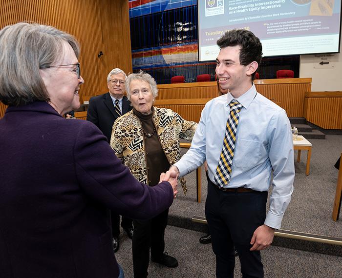 Miller shakes a person's hand