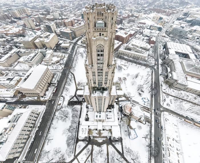 An aerial view of the Cathedral of Learning during the winter that shows its entire front facade.