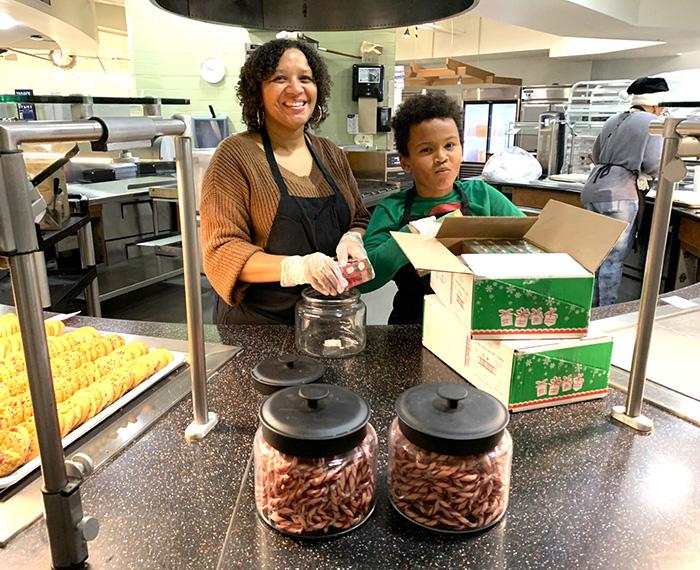 An adult and child volunteer help prepare meals for Christmas Day at Pitt.