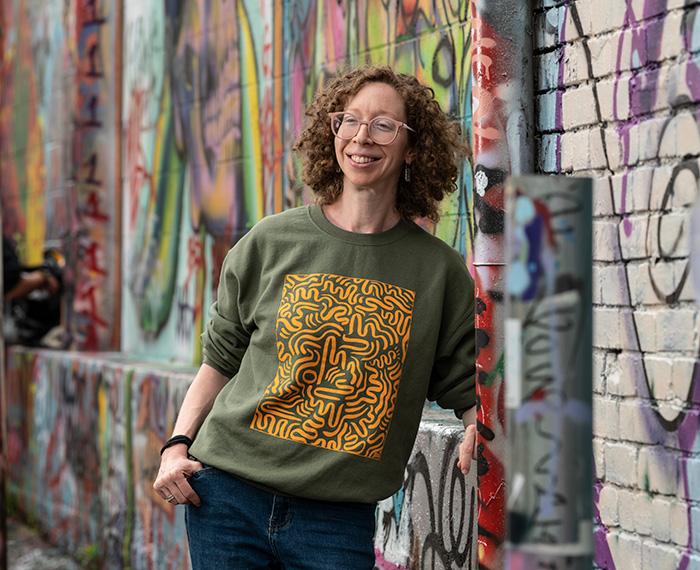Caitlin Bruce standing in front of a wall of street art
