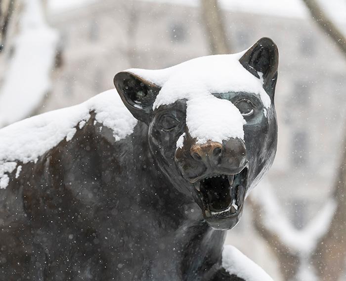 Snow falls on a panther statue