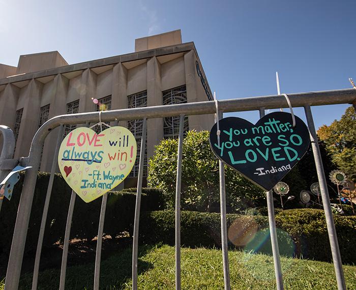 Heart-shaped signs outside the Tree of Life Synagogue reading "Love will always win" and "You matter. You are so loved."
