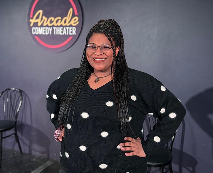 Portait of Sydney DuBose with logo of the Arcade Comedy Theater in the back