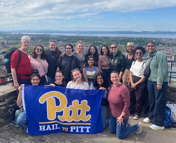 Students holding flag reading "Pitt: Hail to Pitt"