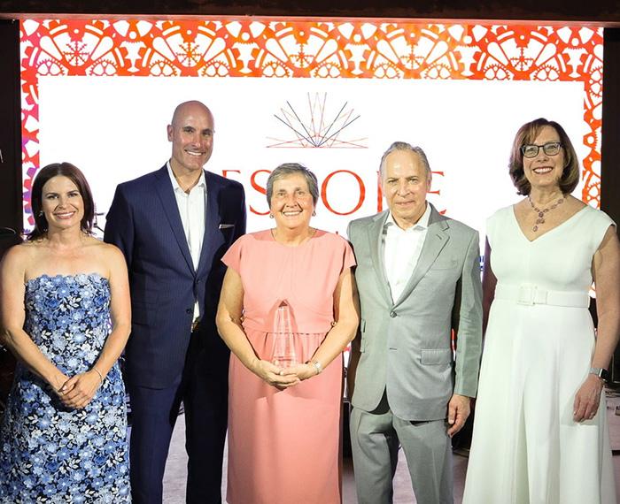 Olivera Finn receiving an award, surrounded by four other people dressed up.
