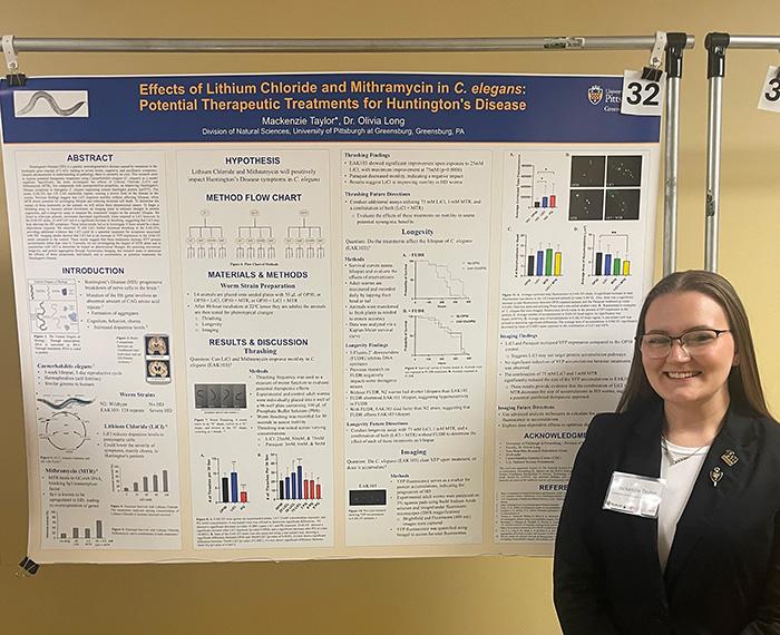 Mackenzie Taylor in front of her poster “Effects of Lithium Chloride and Mithramycin in C. elegans: Potential Therapeutic Treatments for Huntington’s Disease.”