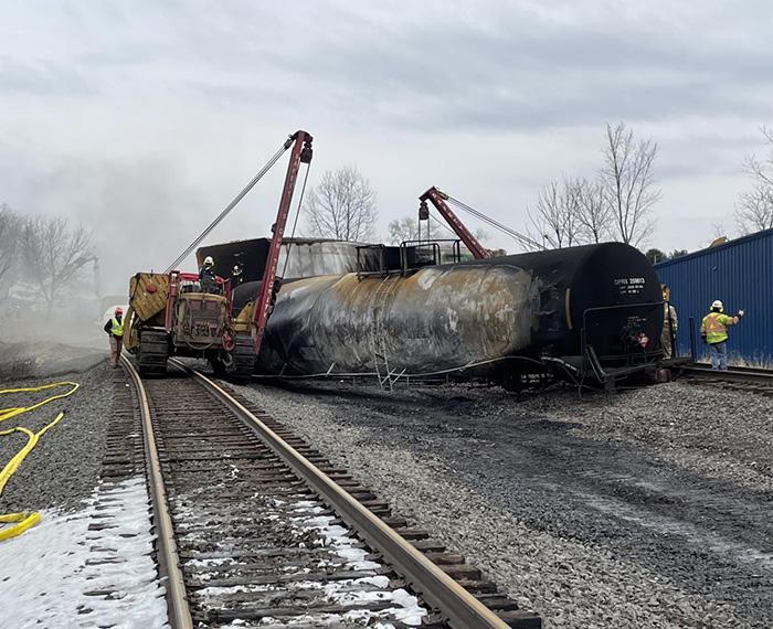 A crew removes a damaged train car from the track