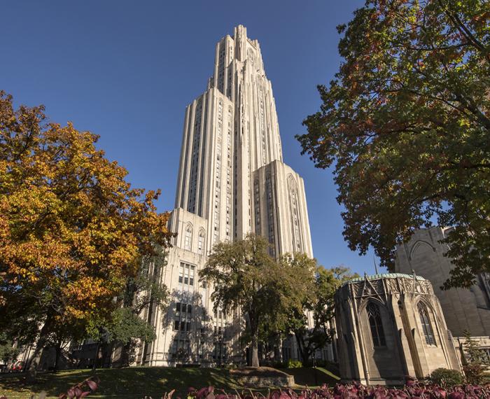 The Cathedral of Learning framed by trees in the fall