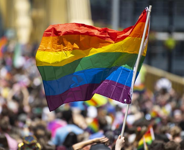 A pride march with a rainbow flag flying