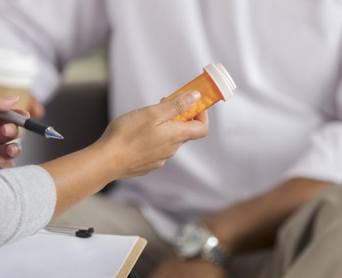 A physician holding a bottle of pills