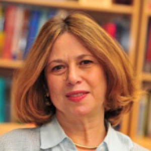 Ivet Bahar in a light blue collared shirt with bookcases in the background