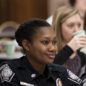 Police officers sit at a table in their uniforms. 