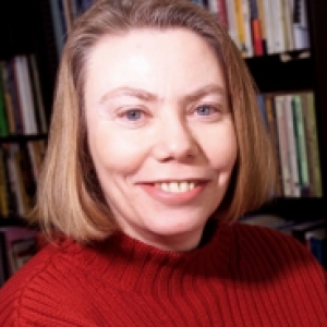 young in a red sweater in front of a bookcase
