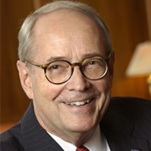 A man in glasses and a dark suit jacket