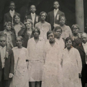 A black and white group photo including Isma Burrell on the steps of a church building