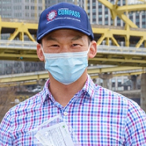 Ho in a blue and pink plaid shirt holding a testing kit