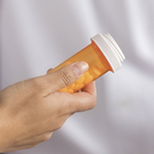 A physician holding a bottle of pills