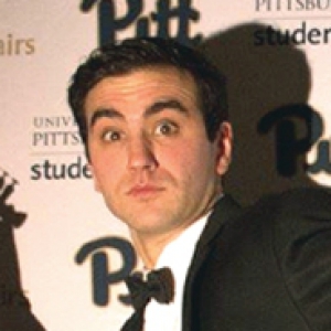 Irwin in front of an award-show background, wearing a tux