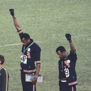 Tommy Smith and John Carlos on a podium holding their fists in the air