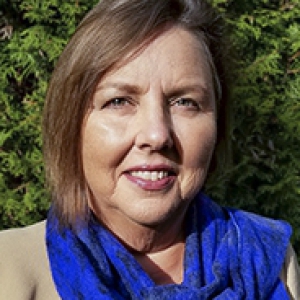 Headshot of Catherine Koverola, against background of greenery