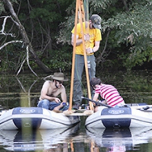 three people taking samples from a lake