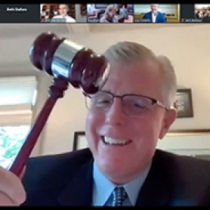a Zoom screenshot, where Richards is holding a gavel and smiling