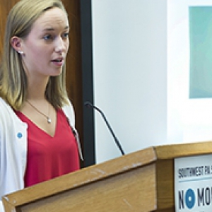 Maggie Kennedy, a peer educator, standing at a podium