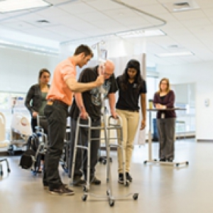 Therapists assist a person in a walker