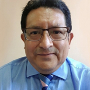 A man with glasses in a blue dress shirt with a striped blue tie