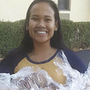 a young woman holding bags of bread to donate