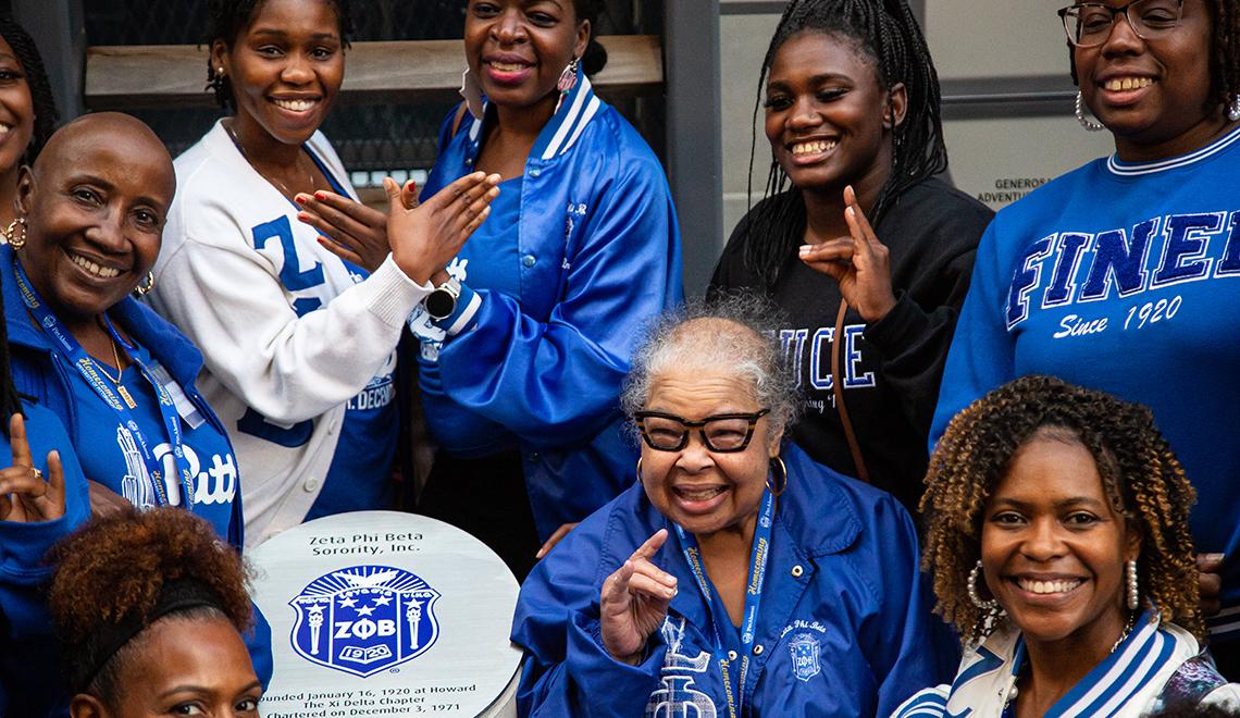 People wearing blue Pitt jackets smiling for group photo