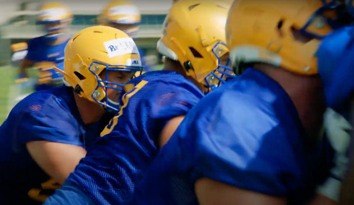 Football players in yellow helmets and blue jerseys